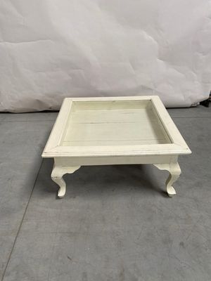 une photo représentant un petit plateau en bois blanc posé sur un sol gris