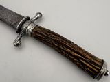 a close up of a knife with a wooden handle on a white surface