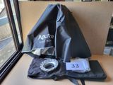 un sac contenant un appareil photo, posé sur une table près d'une fenêtre
