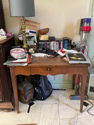 un bureau sur lequel s'entassent toutes sortes d'objets