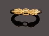 a gold - plated ring with leaves and a black stone