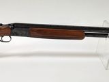 un fusil de chasse à canon en bois posé sur un support transparent