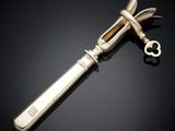 un couteau en argent avec un manche en métal posé sur une surface noire