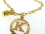 the initial k is inscribed in gold on a gold plated necklace