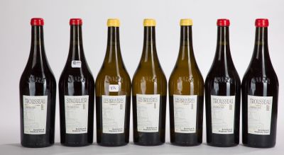 six bottles of wine lined up in a row on a white surface