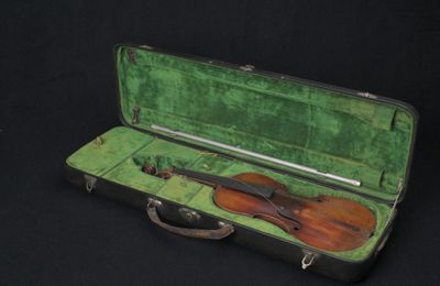 un violon dans un étui vert sur fond noir
