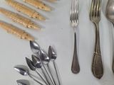 many different types of spoons and forks laid out on a table