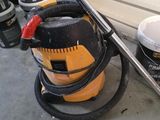 un aspirateur jaune et noir posé par terre à côté de quelques seaux de peinture