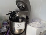 un mixeur argenté posé sur un plan de travail en métal dans une cuisine