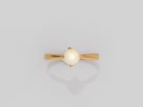 une bague en or avec une perle blanche au centre