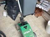 a machine that is sitting on the floor next to a trash can