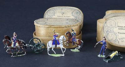 plusieurs figurines représentant des personnes à cheval ou dans des calèches devant une boîte
