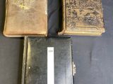 three old books sitting on top of a black table next to each other