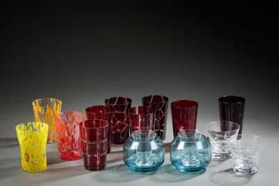 de nombreux vases et verres en verre de différentes couleurs sur la table
