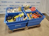 deux bacs bleus remplis d'objets divers, posés sur une palette en bois