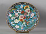 une assiette bleue décorée de fleurs et d'oiseaux