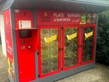 un distributeur automatique rouge installé à l'extérieur d'un immeuble