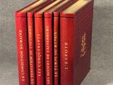 quatre livres rouges empilés les uns sur les autres sur une table