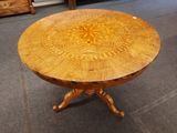 une table en bois dont le plateau est orné d'un motif circulaire