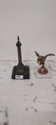 a statue of a bird on a pedestal next to a statue of a bird on a pedestal