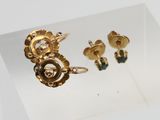 une photo d'un ensemble composé d'une bague et d'une boucle d'oreille en or, exposé en vitrine