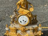 une horloge en or posée sur un socle en marbre