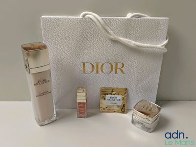 Produits de soin Dior présentés sur une table blanche, accompagnés d'un sac blanc