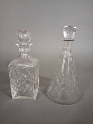 two glass bottles sitting next to each other on a table
