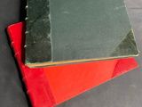 three books are stacked on top of each other on a table