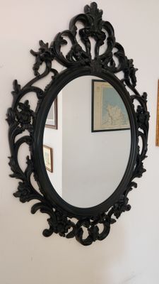 un miroir sur le mur au-dessus d'un lavabo dans une salle de bains