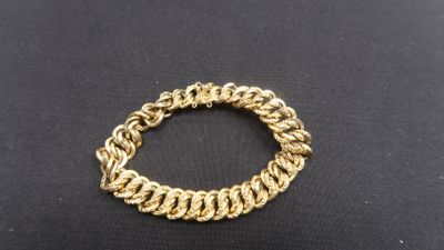 a close up of a gold bracelet on a black surface