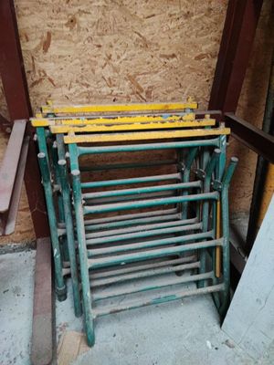 une pile de chaises vertes et jaunes devant un immeuble