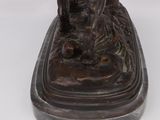bronze statue of a man on a boat with a dog on it