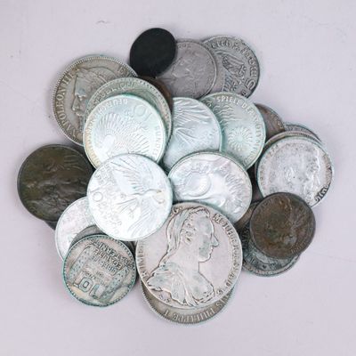 a pile of silver and silver coins on a white surface