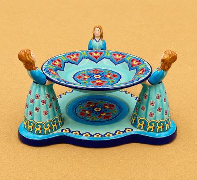 Deux figurines représentant deux femmes en robe bleue sont posées sur une table