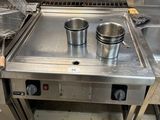 a stainless steel stove with two pots on top of it