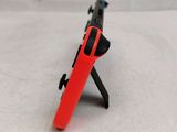 a red nintendo wii controller with a black handle