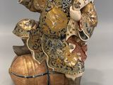 chinese figurine of a laughing man on a ball with a brush