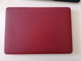 un ordinateur portable rouge posé sur une table à côté d'un clavier