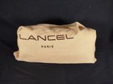 a close up of a tan bag on a black background