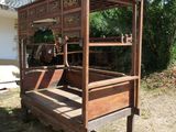 a wooden bed that is sitting in the grass