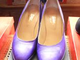 pair of purple shoes sitting on top of a box next to a pair of black shoes