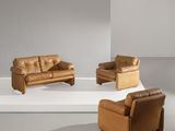 deux canapés en cuir marron et un fauteuil dans une pièce blanche