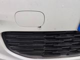 the front bumper of a white car with a blue sticker on it