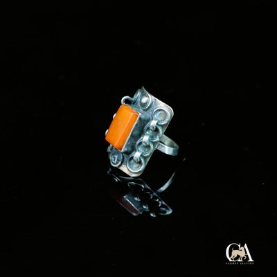 Gros plan sur une bague contenant une pierre orange