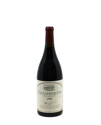 the bottle of wine is sitting on a white surface
