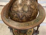 un vieux globe terrestre posé sur un socle dans une pièce
