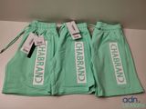 two pairs of mint green pants with white lettering on them
