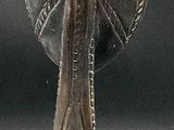 a metal sculpture of a man holding a ball on his head