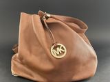 a brown michael kors handbag with a gold michael kors logo on the front